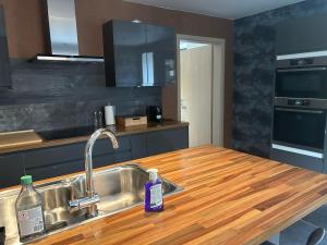 a kitchen with a sink and a wooden counter top at Family lodge - Domaine aux charmes d'Ethan in Hannut