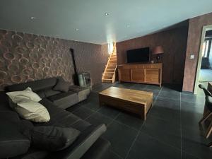 a living room with a couch and a television at Family lodge - Domaine aux charmes d'Ethan in Hannut