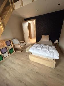 a bedroom with a large bed and two chairs at Family lodge - Domaine aux charmes d'Ethan in Hannut +18 photos
