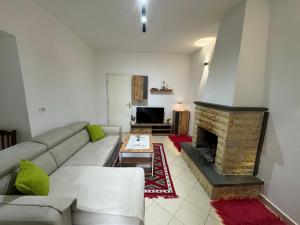 a living room with a couch and a fireplace at Green House Permet in Përmet