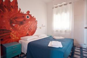 a bedroom with two beds and a painting of a fish at Relais Al Faro Bed&Breakfast in San Domino