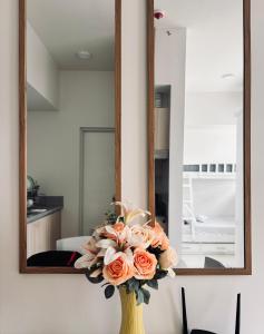 a yellow vase with flowers in front of a mirror at Budget Bunk Studio Comfort in Iloilo City