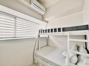 a small bedroom with a bunk bed and a window at Budget Bunk Studio Comfort in Iloilo City +14 photos