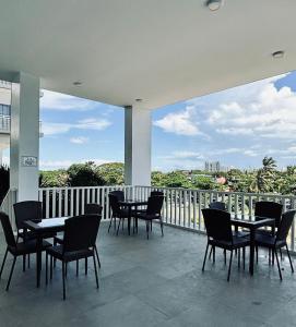 a patio with tables and chairs on a balcony at Budget Bunk Studio Comfort in Iloilo City