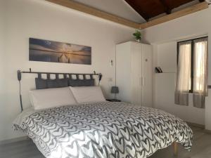 a bedroom with a bed with a black and white comforter at COSY LITTLE HOME in Mergozzo