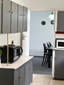 a kitchen with a microwave and a table with chairs at Heart of Numbi Villa in The Sands