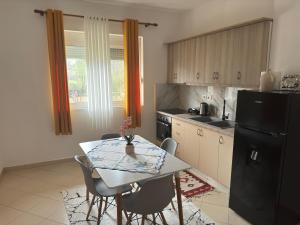 a kitchen with a table and a black refrigerator at Green House Permet in Përmet