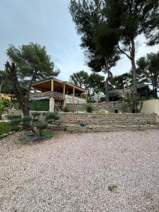 a house with a stone retaining wall and trees at Bentley studio in Sanary-sur-Mer