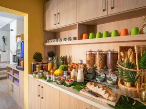 a shelf filled with different types of food in a kitchen at ibis Styles Beaulieu sur Mer in Beaulieu-sur-Mer