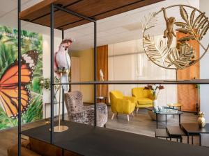 a living room with a butterfly mural and chairs at ibis Styles Beaulieu sur Mer in Beaulieu-sur-Mer