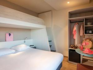 a bedroom with a large white bed and a table at ibis Styles Beaulieu sur Mer in Beaulieu-sur-Mer