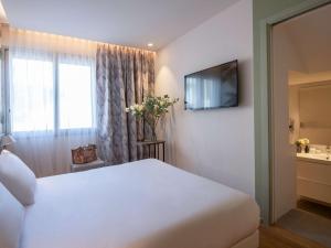 a hotel room with a white bed and a window at ibis Styles Beaulieu sur Mer in Beaulieu-sur-Mer