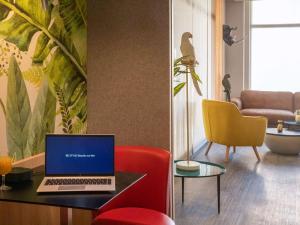 a living room with a laptop computer on a table at ibis Styles Beaulieu sur Mer in Beaulieu-sur-Mer