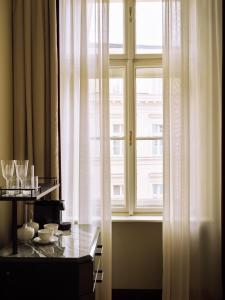 a window with white curtains and a table in front of it at Sir Prague, part of Sircle Collection in Prague