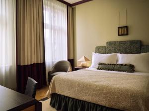 a bedroom with a bed and a chair and a window at Sir Prague, part of Sircle Collection in Prague