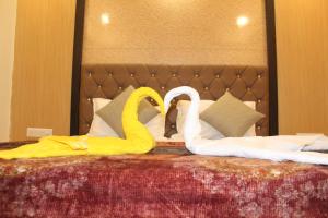 瓦皮Hotel Skylark的两个天鹅在床上做心形