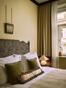 a bedroom with a bed with white sheets and green pillows at Sir Prague, part of Sircle Collection in Prague