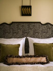 a bed with white pillows and a headboard with green pillows at Sir Prague, part of Sircle Collection in Prague