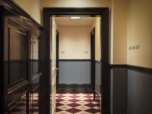 a hallway with a door and a checkered floor at Sir Prague, part of Sircle Collection in Prague