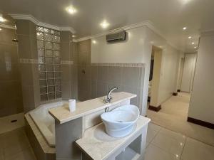 a bathroom with a sink and a bath tub at Casa3 Eastgate Mall in Johannesburg