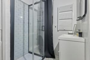 a white bathroom with a shower and a sink at Château Émeraude, T2 hypercentre, Terrasse, Charme et détente in Château-Thierry +21 photos