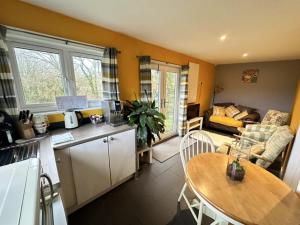 a kitchen and living room with a table and a dining room at The Cabin Leat Road in Lifton