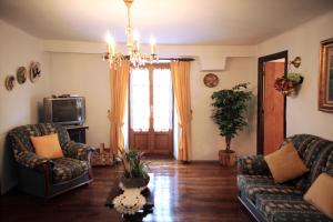 a living room with a couch and chairs and a television at Casa Rural Mokorrea in Etxalar