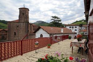 a building with a red fence and a church at Casa Rural Mokorrea in Etxalar