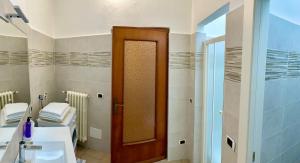 a bathroom with a wooden door and a sink at Idro Appartamenti - Vantone in IDRO
