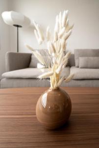 a brown vase with white flowers sitting on a table at Vue imprenable - Garage privé in Rennes
