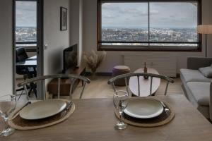 a dining room table with plates and glasses on it at Vue imprenable - Garage privé in Rennes