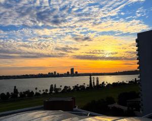 a sunset over a body of water with a city at Residence on Langley Park in Perth +117 photos