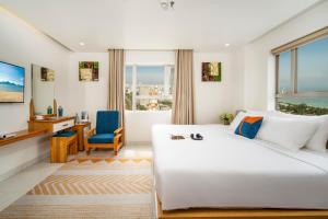 岘港Ocean Bliss Hotel - Free Sauna的卧室里有一张白色的大床和一张书桌