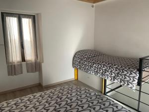 a small room with a bunk bed and a window at COSY LITTLE HOME in Mergozzo