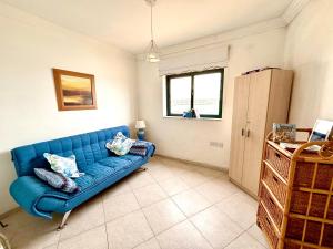 a blue couch sitting in a living room at Mellieha Seaside Apartment in Mellieħa