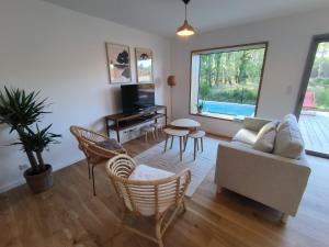 a living room with a couch and chairs and a piano at Villa Holidays Ocean in Messanges
