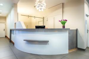 a lobby with a reception desk with a vase of flowers at Hapimag Ferienwohnungen Berlin Zoo in Berlin
