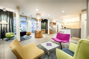 a living room with colorful chairs and a table at Hapimag Ferienwohnungen Berlin Zoo in Berlin