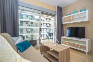 a living room with a couch and a tv and a window at Casa Mariposa Ivan Luxury Homes 3ªPlta Norte 1ªLínea in Oropesa del Mar