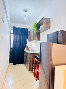 a kitchen with a refrigerator and a sink at Cozy Homes in Nairobi
