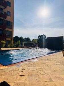 a swimming pool with a fountain in front of a building at Cozy Homes in Nairobi