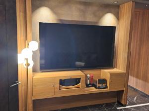 Телевизор и/или развлекательный центр в HOTEL The KAISER -全室人工ラドン温泉-