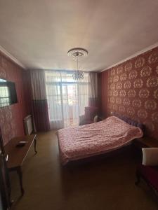 Un dormitorio con una cama y una mesa y una ventana. en MayHouse, en Batumi