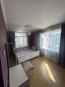 Un dormitorio con una cama y una ventana grande. en MayHouse, en Batumi