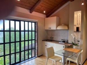 una cucina con tavolo e sedie e una grande finestra di Poderi S Luca ad Alba