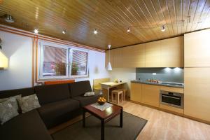 ein Wohnzimmer mit Couch und Küche in der Unterkunft Apartment Bernik II in Kranjska Gora