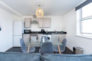 a kitchen with a glass table and blue chairs at Cozy 2 Bed Apartment in City Centre-Free Parking in Southampton