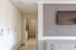 Baño blanco con lavabo y pasillo en Mossel Bay Golf Retreat 1BR Luxury Escape, en Mossel Bay