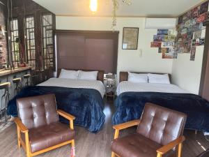 a hotel room with two beds and two chairs at Yokkaichi Guest House in Yokkaichi +37 photos