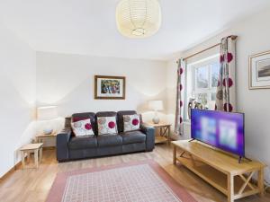 a living room with a couch and a tv at Tollymore Forest family house Mourne Mountains in Bryansford